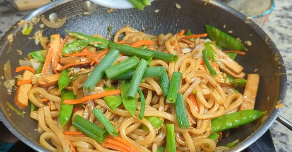 Green Onions added to stir fried vegetable udon noodles