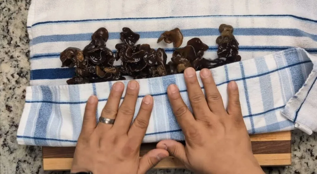 patting wood ear mushrooms on a kitchen towel