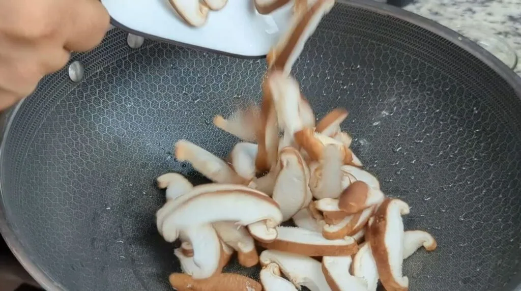 Adding Mushrooms to Wok to Sauté