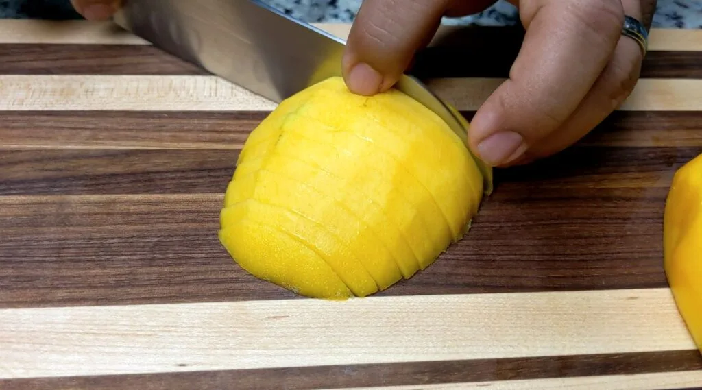 Slicing ripe Mango on a cutting board