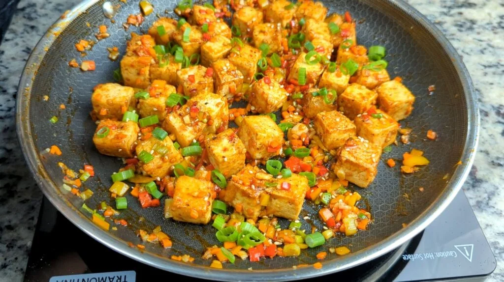 Chili Garlic Tofu garnished with Green Onions and Sesame Seeds