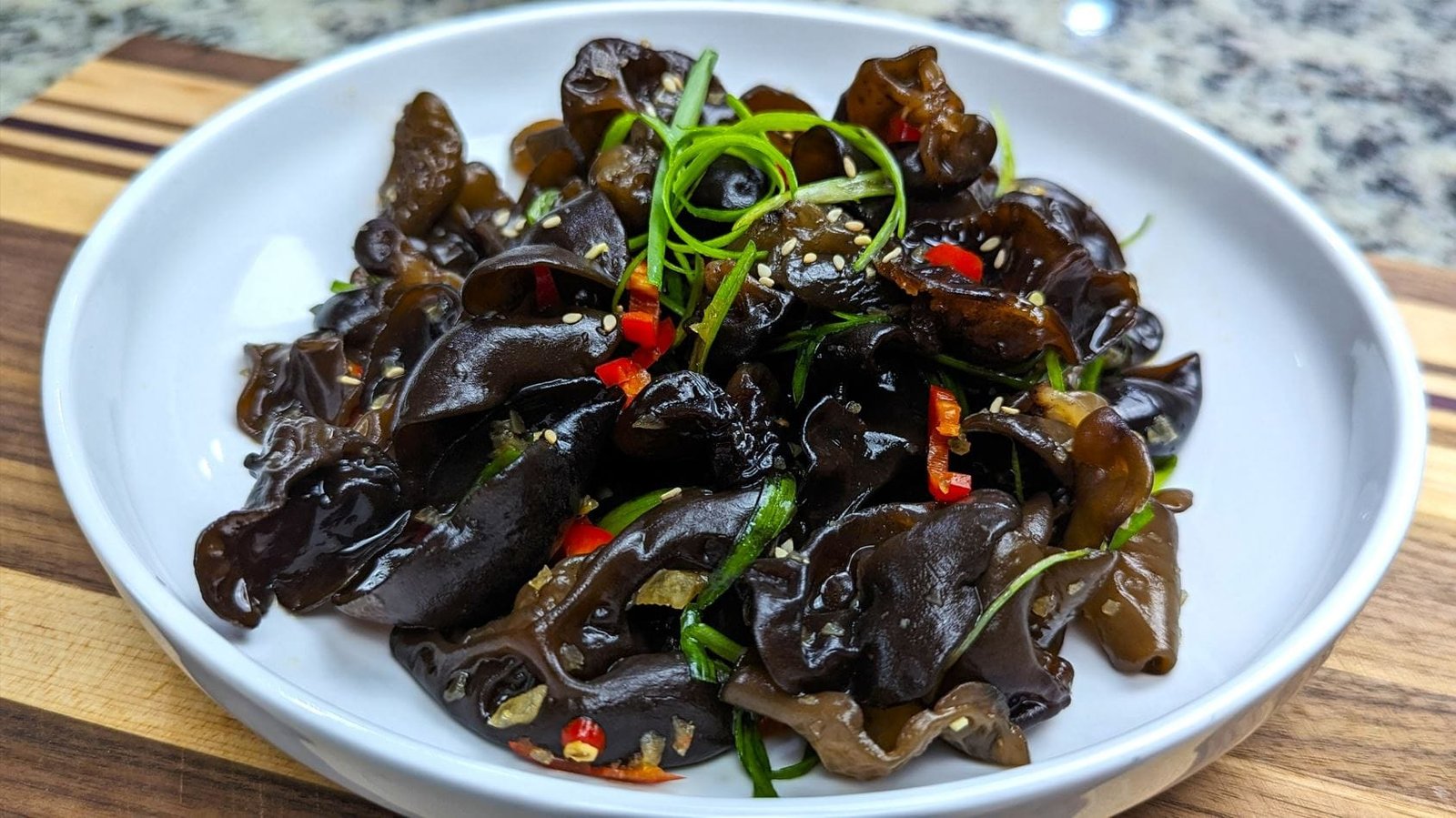 Wood ear mushroom salad plated in a white bowl with garnish