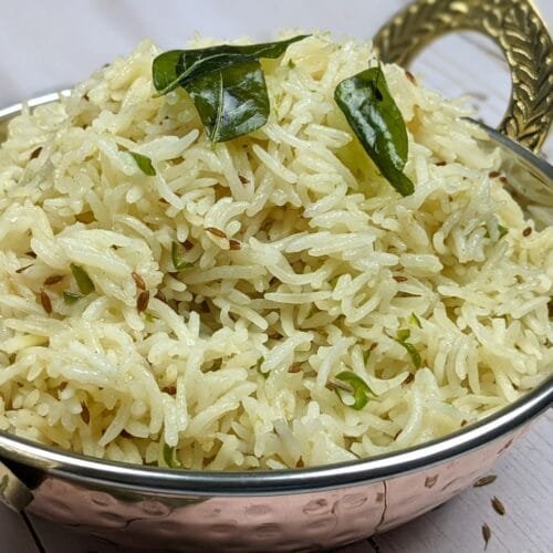 Jeera Rice (Cumin Rice) in a traditional serving bowl with curry leaves