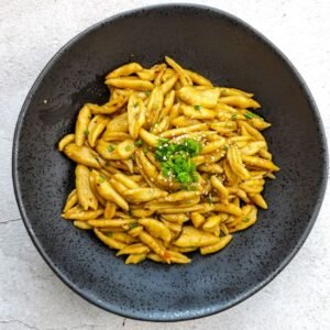 Scissor Cut noodles stir fry in a black plate top view