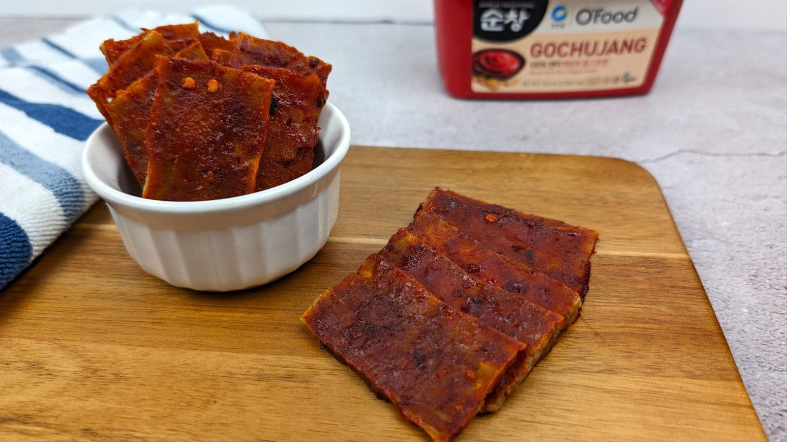 Gochujang Tofu Jerky placed on a wooden plank