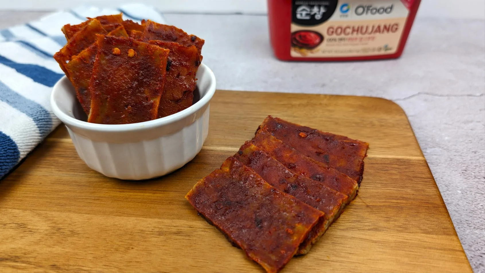 Gochujang Tofu Jerky placed on a wooden plank