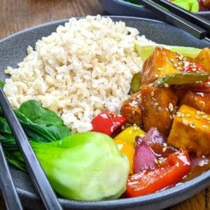 Sweet and Sour Tofu with Brown Rice in a grey bowl