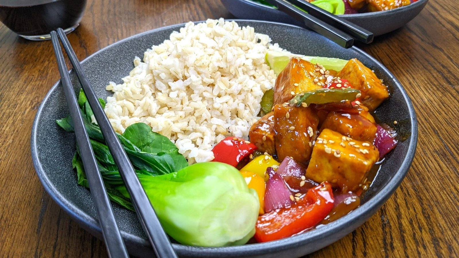 Sweet and Sour Tofu with Brown Rice in a grey bowl