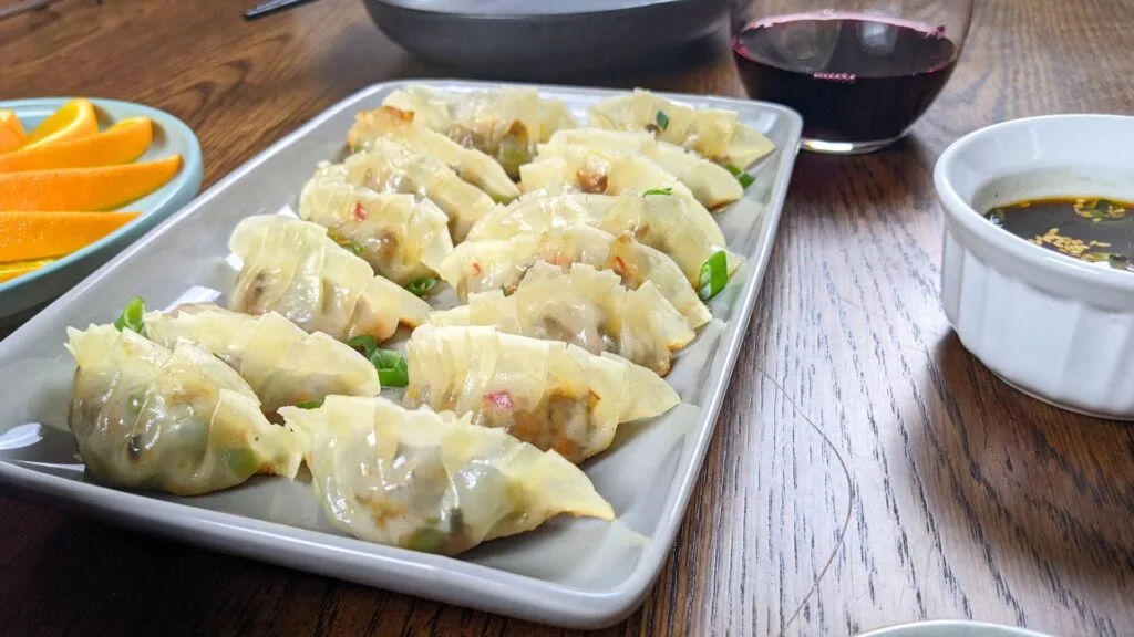 Cooked Vegetable Gyoza on a plate with dipping sauce