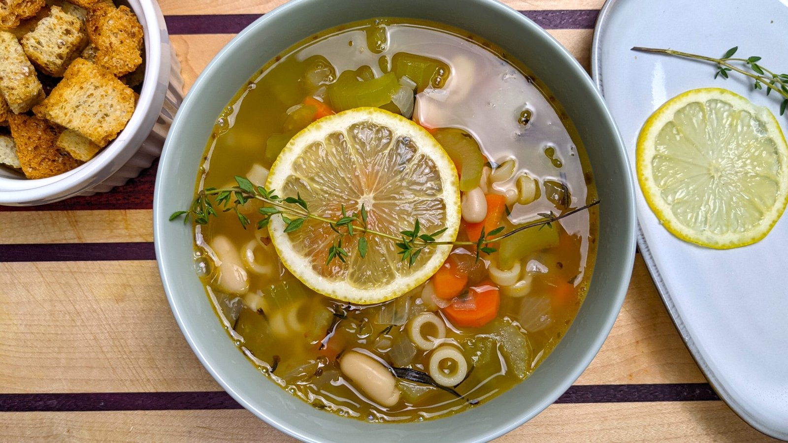White Bean Pasta Soup served in a bowl with croutons on the side