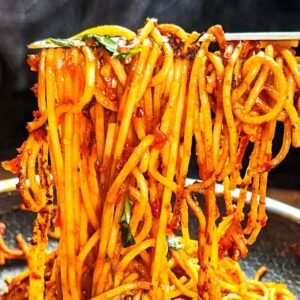 Spaghetti All'assassina being lifted with tongs