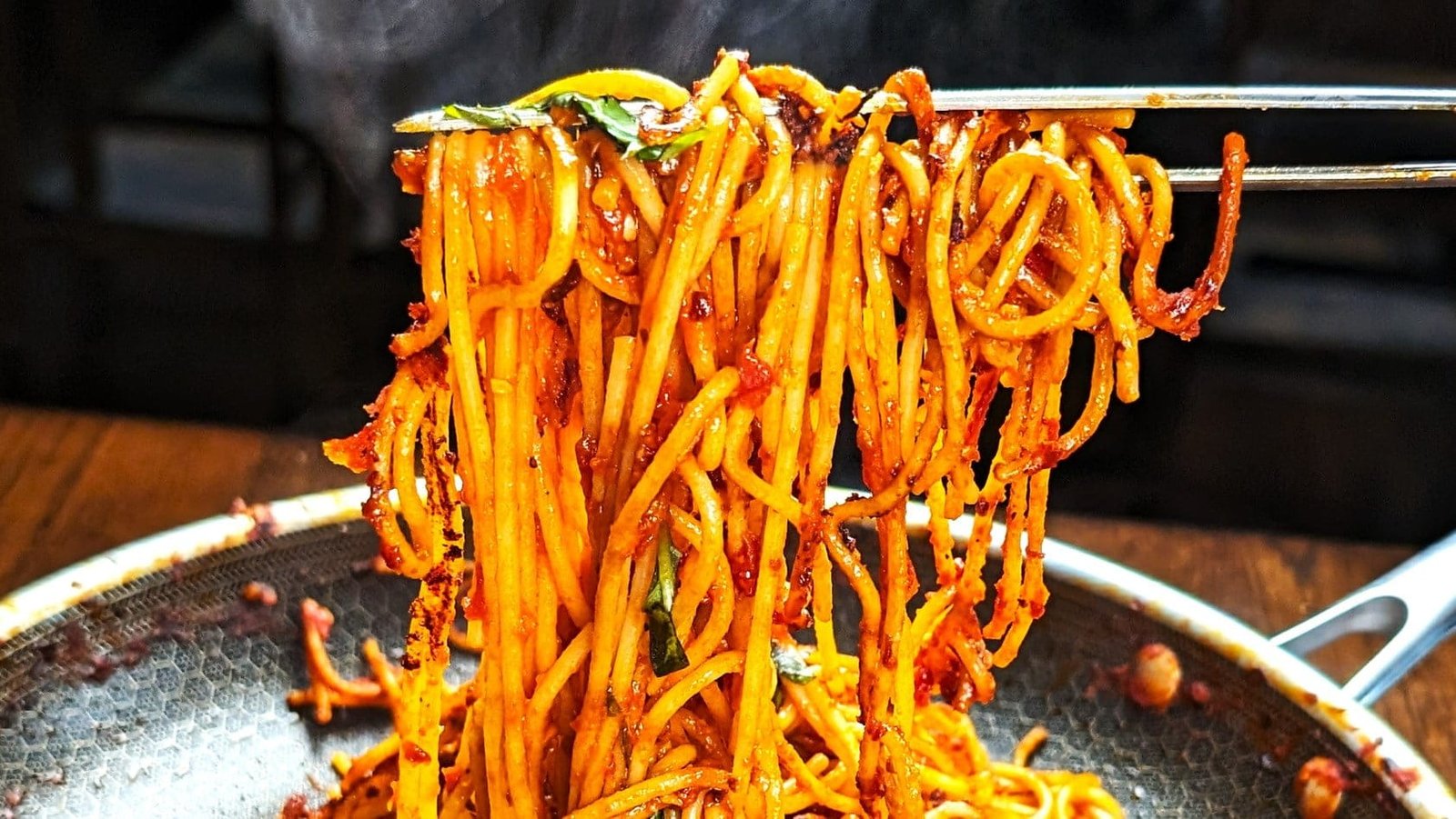 Spaghetti All'assassina being lifted with tongs