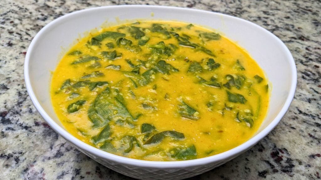 Spinach and Lentil dal is ready in a white serving bowl