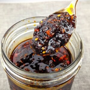 Chili Crisp on a spoon from a mason jar