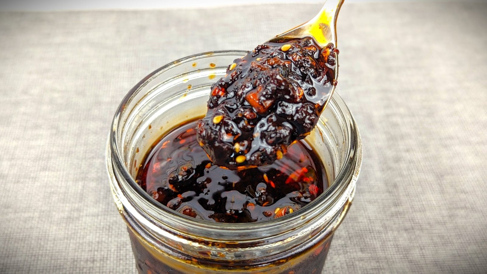 Chili Crisp on a spoon from a mason jar