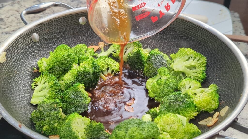 Adding sauce in the middle of hot wok for vegan beef broccoli