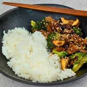 Vegan Beef and Broccoli served with white rice in a black bowl