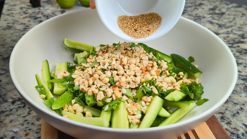 Adding Ingredients in a White Bowl to make Peanut & Chili Oil Cucumber Salad