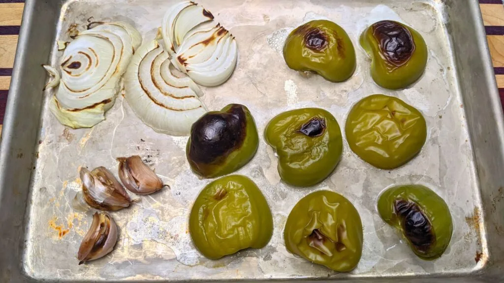 Roasted Tomatoes in a baking sheet with onions and garlic