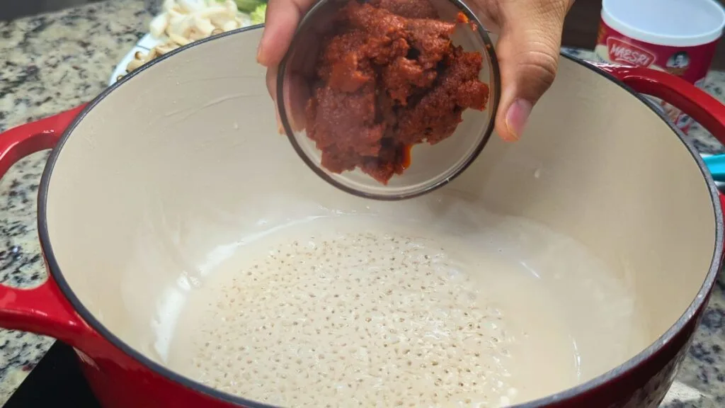 adding Red Curry paste to the Red Dutch OVen