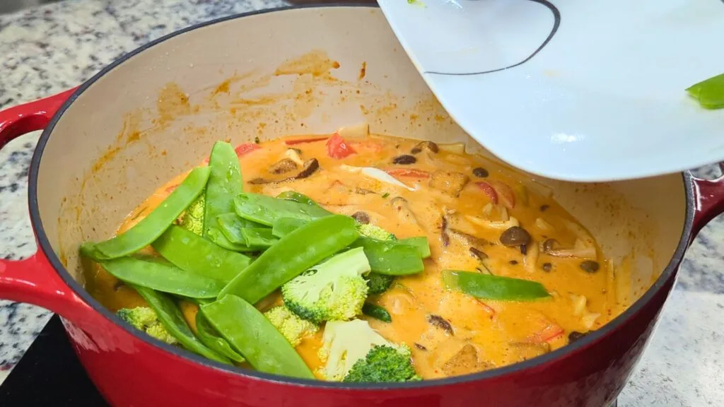 adding vegetable to curry 