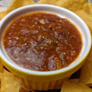 Roasted Tomatillo Salsa served in a bowl surrounded by tortilla chips
