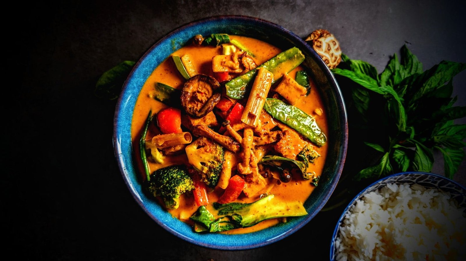 Vegan Tofu Panang Curry with Mushrooms and vegetables in a blue bowl