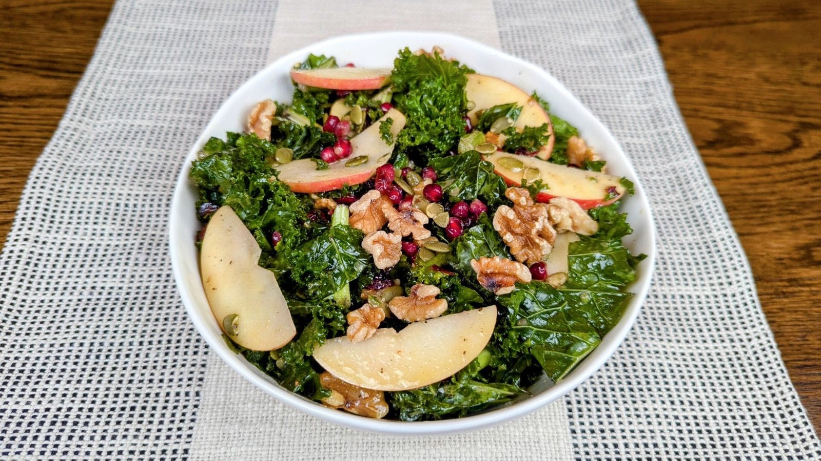 Kale Salad with Apples and Walnuts in a white bowl