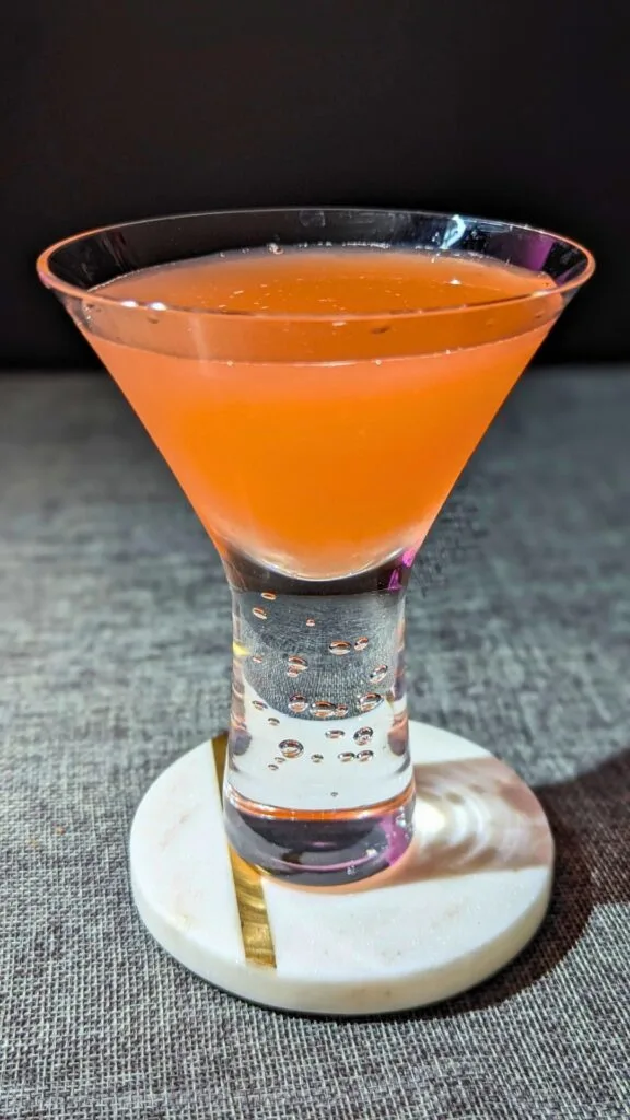 The Siesta Cocktail served in a glass vertical poster