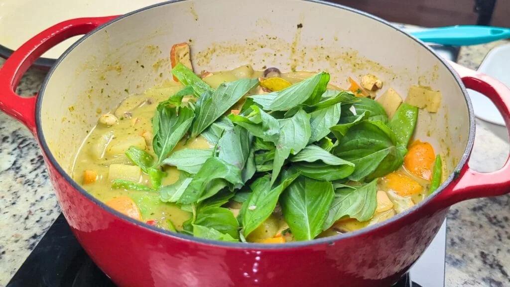 adding Basil leaves to curry