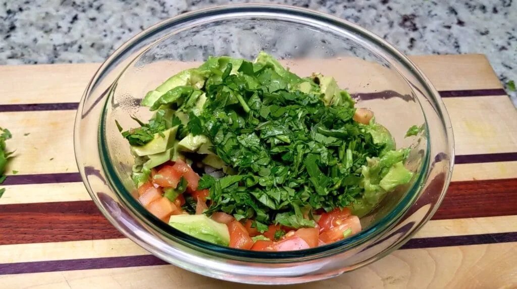 Mixed ingredients in a bowl to make guacamole 