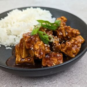Teriyaki Tofu served in a black bowl