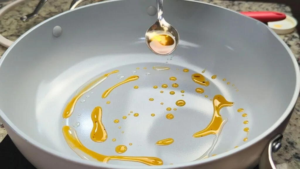 adding oil and chili oil on a hot pan