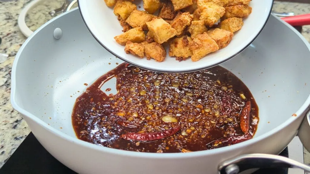 Adding crispy Tofu the the sauce