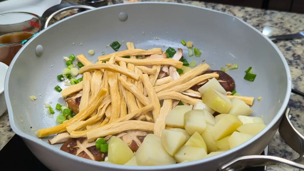adding Potatoes and Yuba in to the pan