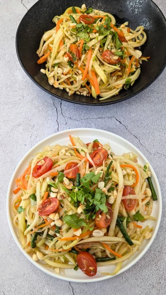 Papaya Salad served in white and black plates vertical image